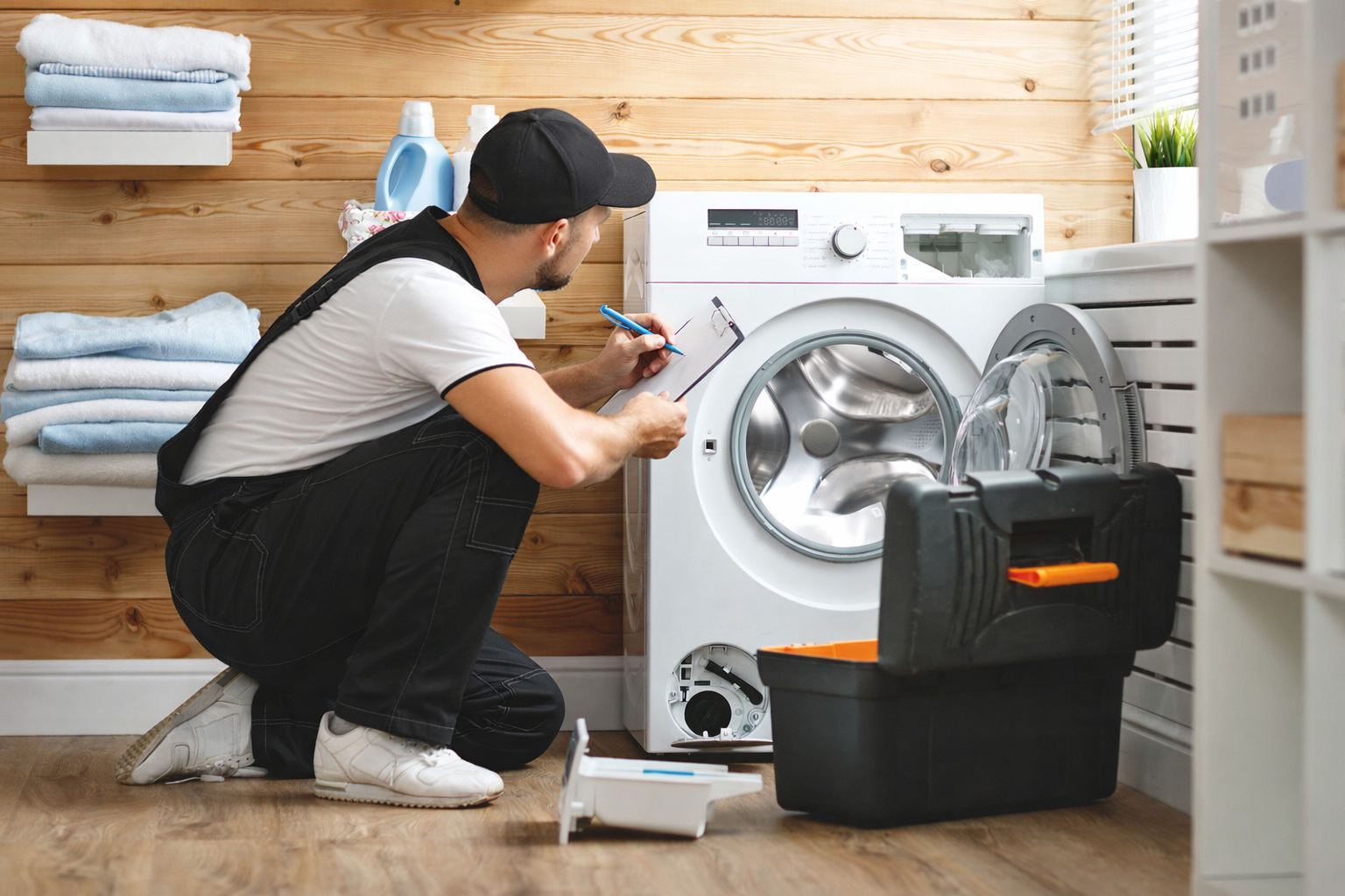 Technicien du service après-vente Monnin Agencement réparant un lave-linge